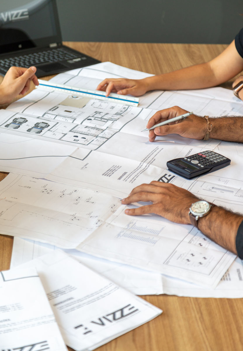 Hands reviewing plans with a calculator